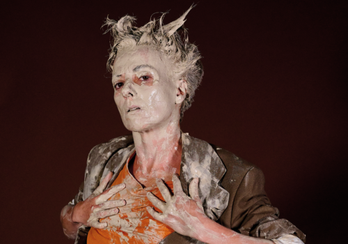 Image of lady with clay in hair and being smeared down chest